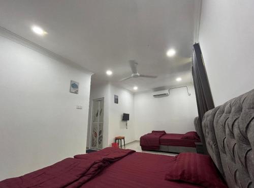 a bedroom with two beds and a ceiling fan at Qiu's Event House superior room in Kuala Berang
