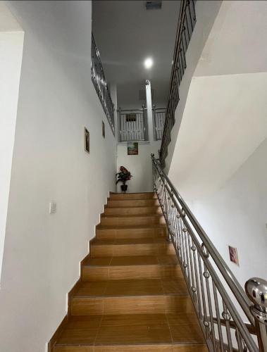 a staircase in a building with wooden floors and white walls at Qiu's Event House superior room in Kuala Berang