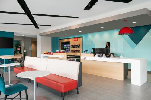 a restaurant with a counter and tables and chairs at Avid Hotels - Roseville - Minneapolis North by IHG in Roseville