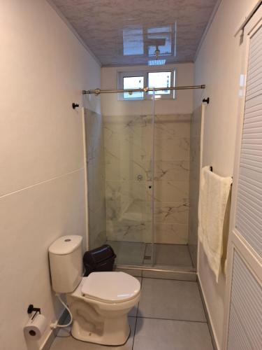 uma casa de banho com um WC e uma cabina de duche em vidro. em Casa Kalamary Crespo em Cartagena das Índias