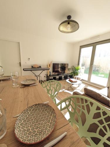 une salle à manger avec une table, des chaises et une télévision dans l'établissement Appartement de Standing avec jardin, à Clamart