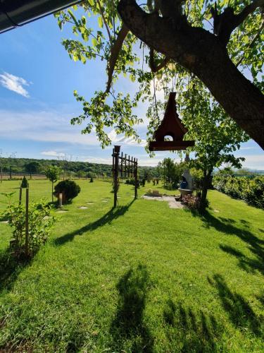 a bell hanging from a tree in a field at Glamping NA BREJGI in Filovci