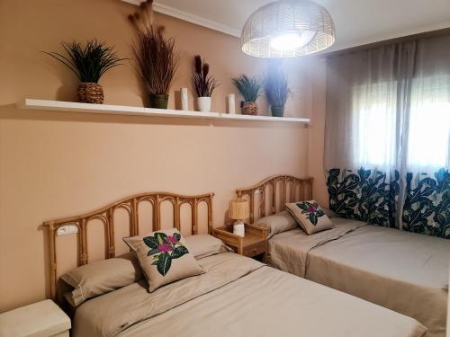 ロケタス・デ・マルにあるVilla Romana con piscina privada y vistas al jardínのベッド2台 壁に植物が飾られた部屋