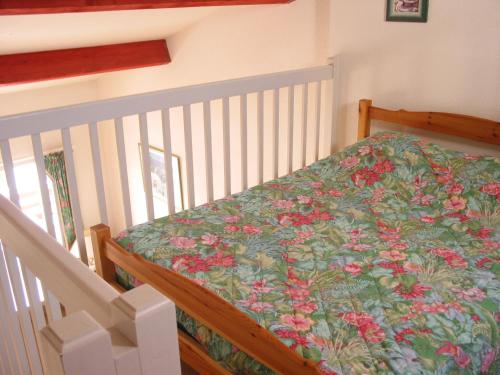 - une chambre avec un lit bébé avec des fleurs dans l'établissement Résidence Green Village, à La Grande Motte