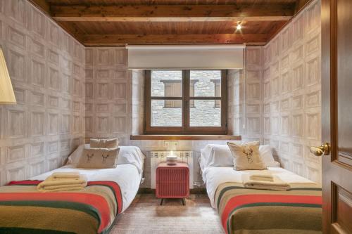 two twin beds in a room with a window at Luderna - Apartamento Val de Ruda B1 Morèdo in Baqueira-Beret