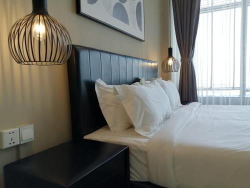 a bedroom with a bed with white pillows and a table at City View Studio in Phnom Penh