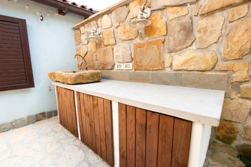 uma cozinha com uma parede de pedra e um balcão em Bivalvia Apartments em Koper