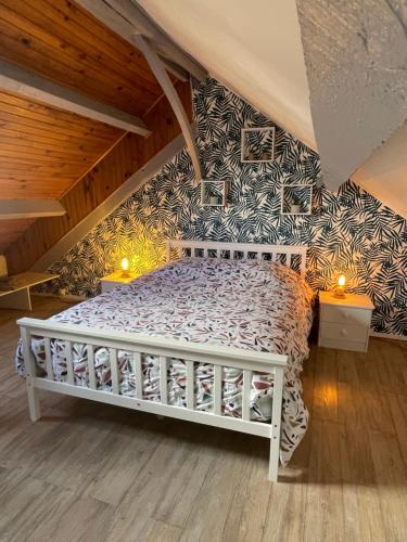 een slaapkamer met een wit bed op zolder bij La Symphorine in Grandvilliers