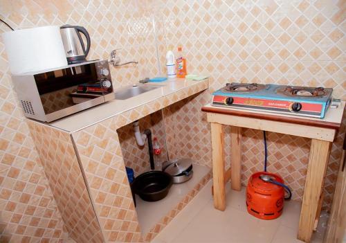 eine kleine Küche mit Herd und Spüle in der Unterkunft Voie lactée in Dakar