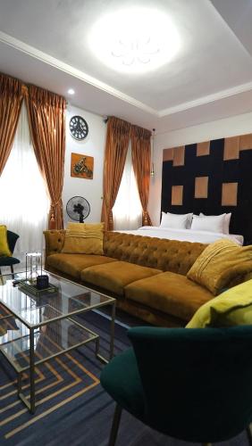 a living room with a couch and a bed at SHORTLETMART Guest House in Lekki