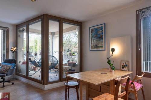 uma sala de jantar com uma mesa de madeira e cadeiras em Cozy 55 m with terrace in Paris em Paris