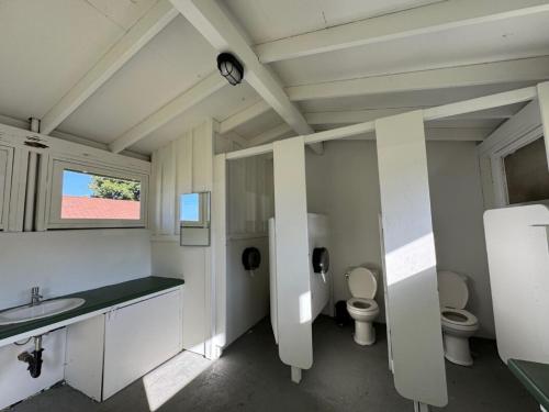 a large bathroom with two toilets and a sink at White’s Landing Catalina Camp in Avalon