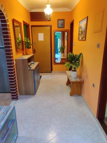 vestíbulo con paredes de color naranja y suelo de baldosa en Apartman Jadranka en Veli Lošinj