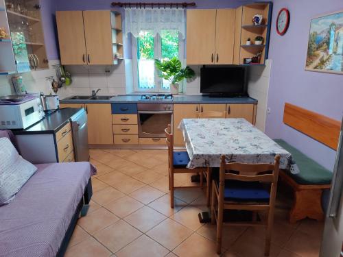 a kitchen with a table and a small kitchen with a table and chairs at Apartman Jadranka in Veli Lošinj