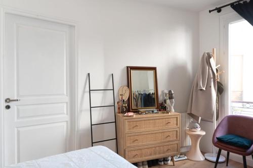 1 dormitorio con espejo y tocador de madera en Cozy 38 m near Père-Lachaise en París