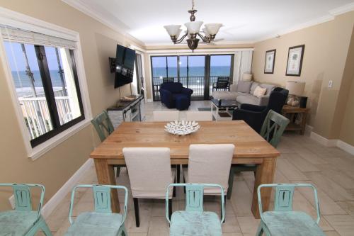 ein Esszimmer und ein Wohnzimmer mit einem Tisch und Stühlen in der Unterkunft Direct oceanfront with stunning corner views and pool access! in New Smyrna Beach