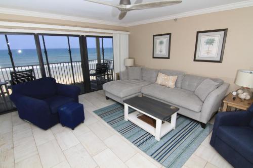 ein Wohnzimmer mit einem Sofa und 2 Stühlen in der Unterkunft Direct oceanfront with stunning corner views and pool access! in New Smyrna Beach