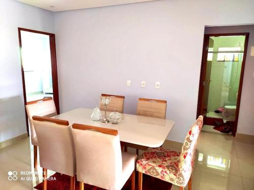 uma sala de jantar com uma mesa branca e cadeiras em Casa linda em Anápolis