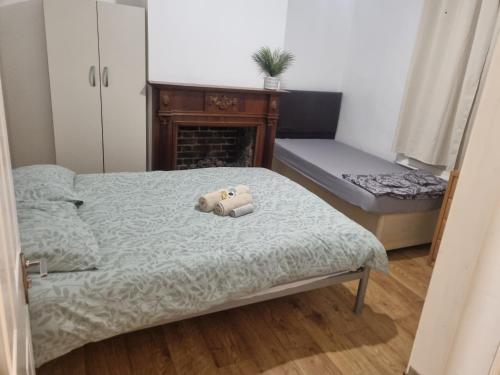 a bedroom with a bed with a teddy bear on it at Cozy House with Character & Garden. in London