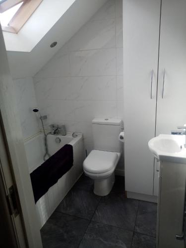 Baño blanco con aseo y lavamanos en Vic's Apartment, en Birmingham