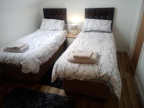 1 dormitorio con 2 camas y toallas. en Vic's Apartment, en Birmingham
