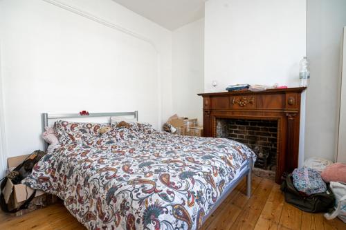 a bedroom with a bed and a fireplace at Cozy House with Character & Garden. in London