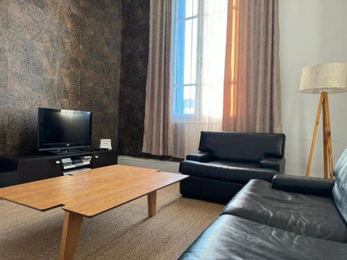 uma sala de estar com um sofá e uma mesa de centro em Bel appartement au centre ville em Tunes