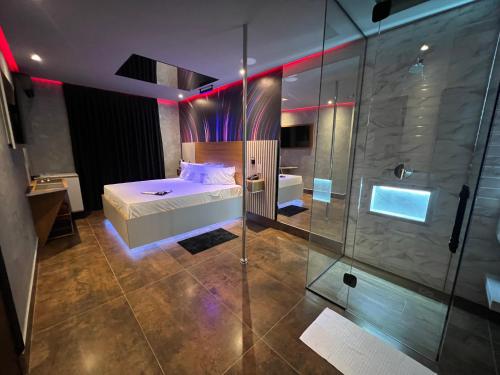 een slaapkamer met een bed en een glazen douche bij Motel Prestige Pinda in Pindamonhangaba