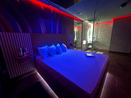 una camera da letto con un grande letto con luci viola di Motel Prestige Pinda a Pindamonhangaba