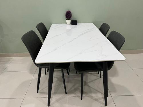 a white table with black chairs and a vase on it at City View Studio in Phnom Penh