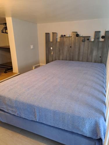 une chambre avec un lit avec une tête de lit en bois dans l'établissement Studio duplex, au Mans