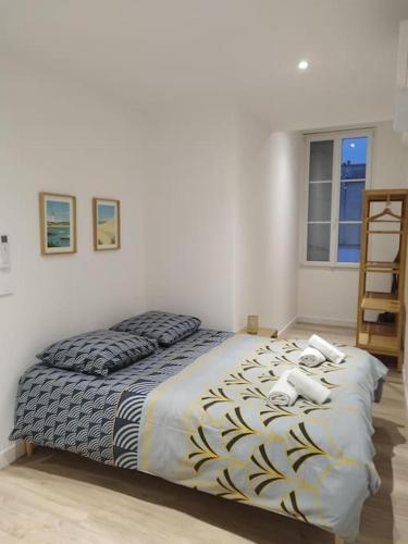 une chambre avec un lit avec deux téléphones dessus dans l'établissement Appartement neuf en plein cœur de la Bastide, à Libourne