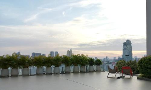 a row of chairs and palm trees on the roof of a building at City View Studio in Phnom Penh