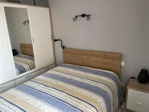 - une chambre avec un lit et deux miroirs dans l'établissement Appartement T2 avec terrasses, à Le Castellas
