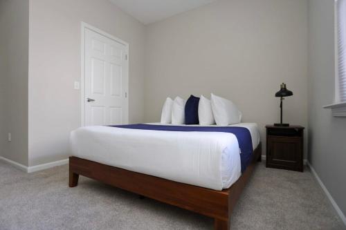a bedroom with a large bed with blue and white pillows at Comfortable Apartment with Pool Gym & other Amenities #2306 in Woburn