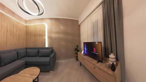 a living room with a couch and a tv at Mouson Luxury Suite With Free Private Parking in Kavala
