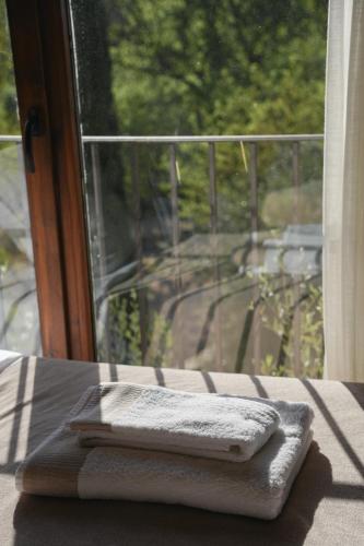a pair of towels sitting on a table in front of a window at Hotel Hort De Fortunyo in Arnés