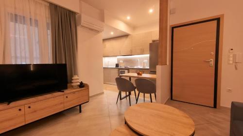 a living room with a television and a table at Mouson Luxury Suite With Free Private Parking in Kavala