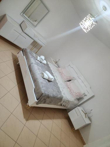 a white room with a bed with towels on it at Angels Apartment in Berat