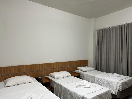 a hospital room with three beds and a window at Norte Palace Hotel in São Mateus