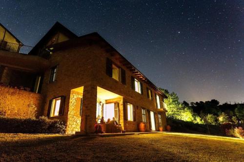 two people sitting outside of a house at night at Villa Greta in Ponti