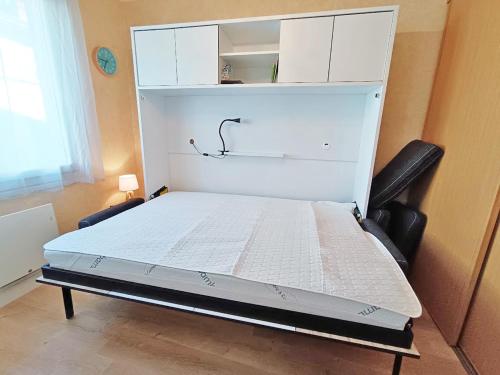 Cette chambre comprend un lit blanc et une armoire. dans l'établissement Les Myrtilles, studio, wifi, cave, 2 personnes, à Luchon