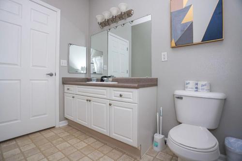a bathroom with a toilet and a sink with a mirror at Comfortable Apartment with Pool Gym & other Amenities #3304 in Woburn