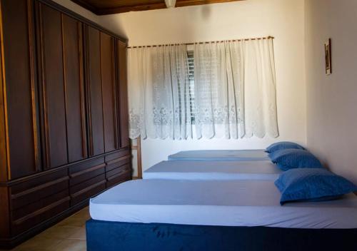 1 dormitorio con 3 camas con almohadas azules y ventana en Canto do Sossego, en Pindamonhangaba