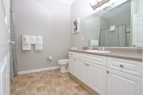 a white bathroom with a sink and a toilet at Comfortable Apartment with Pool Gym & other Amenities #4110 in Woburn