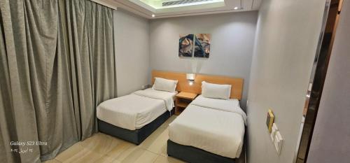 a small room with two beds and a table at رام جده للشقق الفندقيه Ram Jeddah in Jeddah
