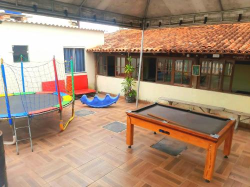 a room with a ping pong table and swings at Flamboyant hostel in Cabo Frio