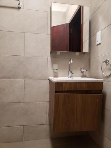 La salle de bains est pourvue d'un lavabo et d'un miroir. dans l'établissement Buildnet 59 Najjera 1, à Kampala