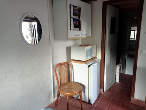 a kitchen with a chair and a microwave on a refrigerator at AlpesAzur in Coursegoules