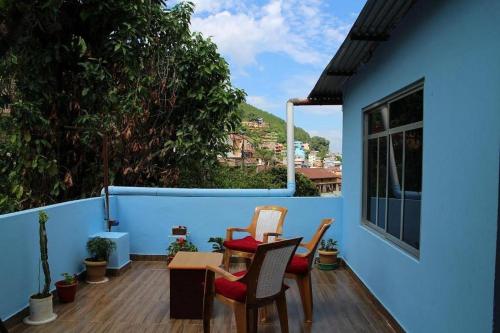 a balcony with two chairs and a table on a blue wall at Sunrise View Homestay in Tānsing